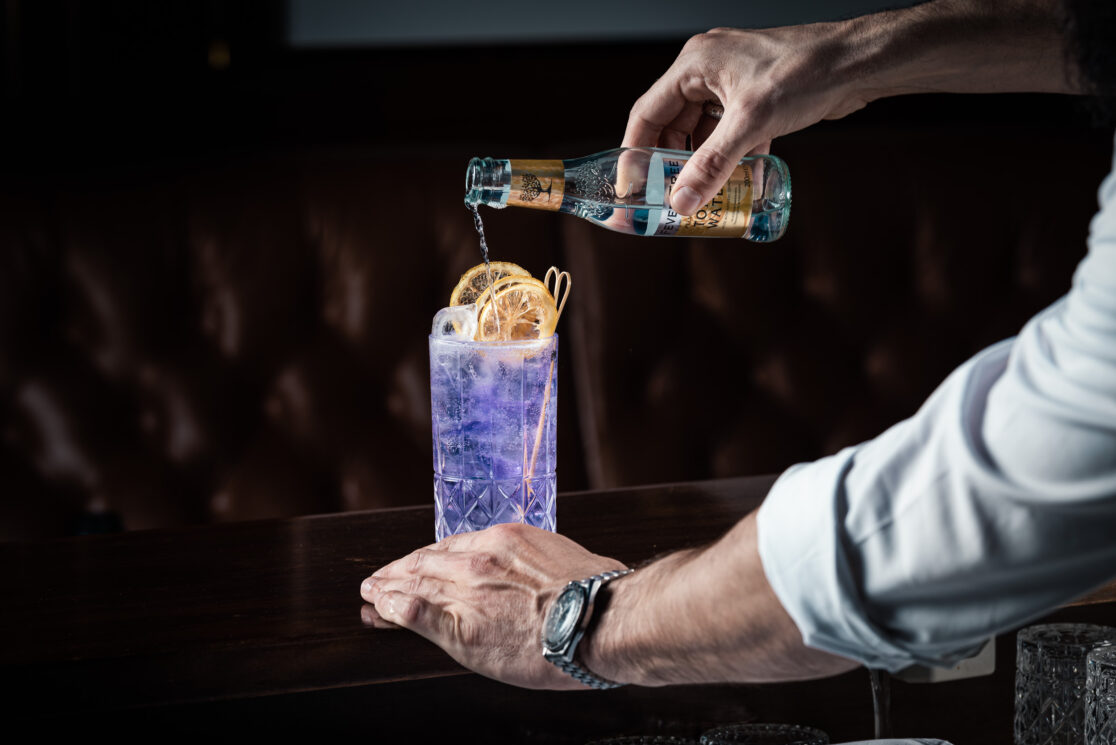 Ein Mann beim einschenken eines Cocktails.