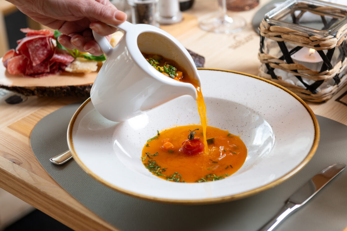 Person giesst eine Suppe ein